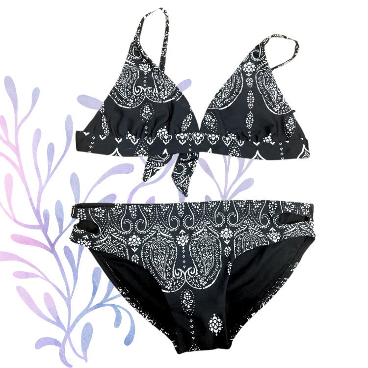Bring out your little surfer girl's sunny style with this Raisins Girls Malibu Bikini Set! This chic black two-piece comes with a handkerchief design that'll add an extra splash of fun to any beach day. She'll be cool and comfortable in the cutout bottoms and mock tie back top – now let's hit the waves!     J740210